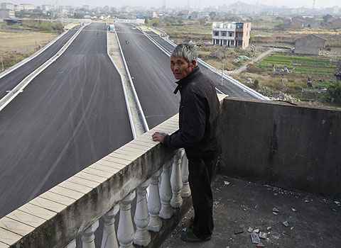 Luo Baogen olha para a estrada que ainda está para ser inaugurada (Aly Song) Luo Baogen olha para a estrada que ainda está para ser inaugurada (Aly Song)